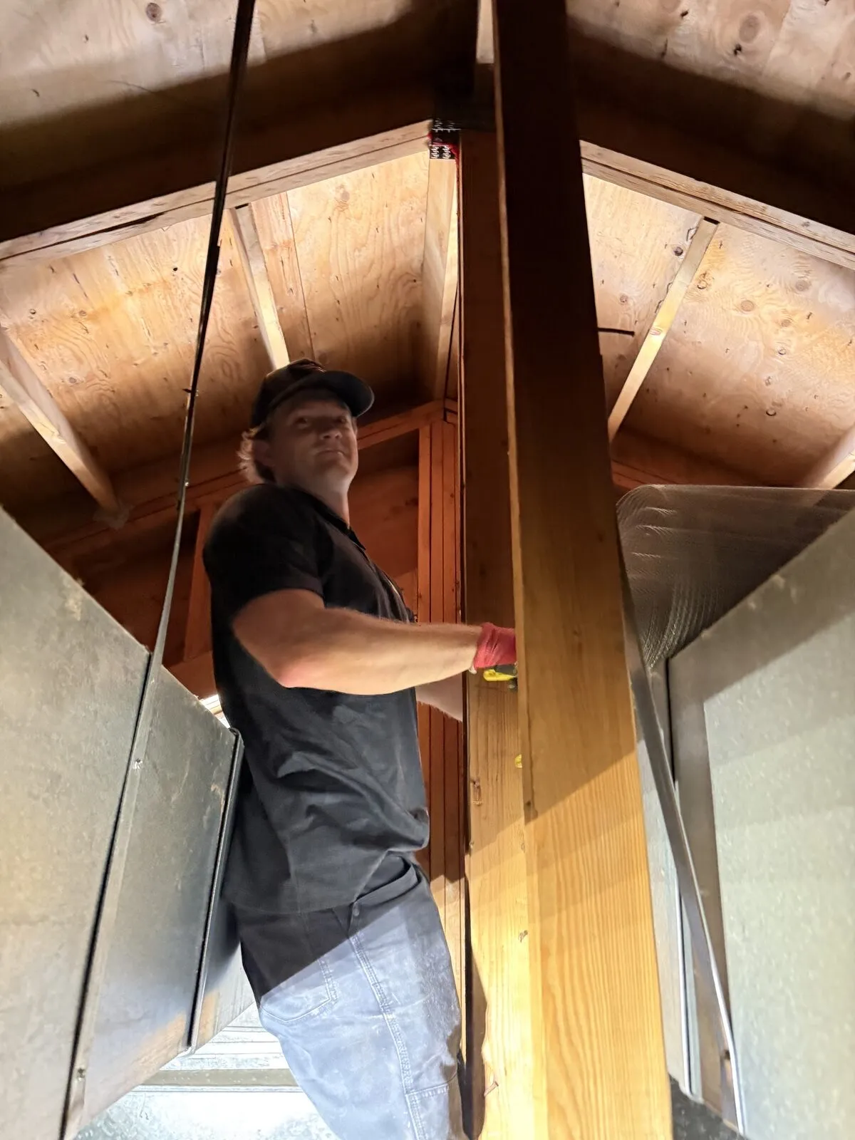 Technician inspecting the framing inside an attic